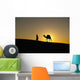 Silhouette of Berber 'Blue man' leading camel across sand dunes Wall Mural