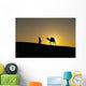 Silhouette of Berber 'Blue man' leading camel across sand dunes Wall Mural