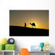 Silhouette of Berber 'Blue man' leading camel across sand dunes Wall Mural