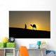Silhouette of Berber 'Blue man' leading camel across sand dunes Wall Mural