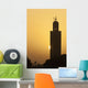 Morocco, Sun setting behind minaret of Koutoubia mosque Wall Mural
