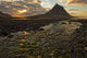 The mountain Kirkjufell rises above the ocean as the sun sets Wall Mural