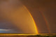 Double rainbow over a prairie field after a storm Wall Mural