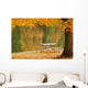 A picnic table beside a tranquil lake with golden leaves on the trees Wall Mural