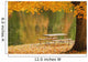 A picnic table beside a tranquil lake with golden leaves on the trees Wall Mural