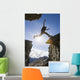 Backlit View Of Hiker Leaping Between Rocks Near Noatak River Wall Mural