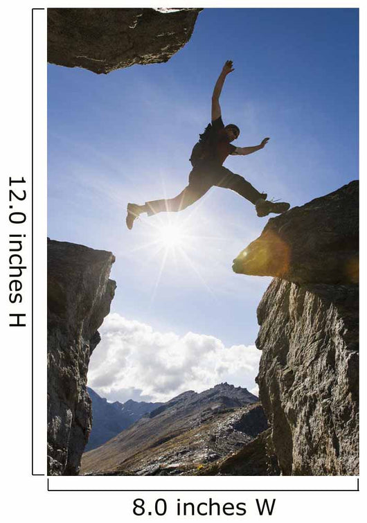 Backlit View Of Hiker Leaping Between Rocks Near Noatak River Wall Mural