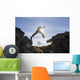 Backlit View Of Hiker Leaping Between Rocks Near Noatak River Wall Mural