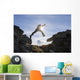 Backlit View Of Hiker Leaping Between Rocks Near Noatak River Wall Mural