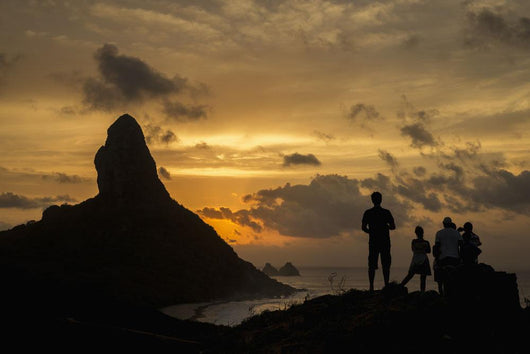 People admiring sunset over Morro do Pico from Forte dos Remedios Wall Mural