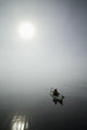 A Sea Kayaker Paddles Into Thick Fog On On A Calm Morning Wall Mural