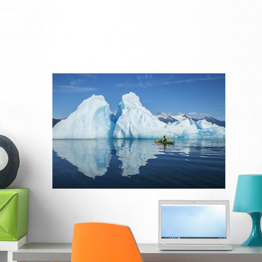 A Sea Kayaker Paddles Beside An Iceberg Wall Mural