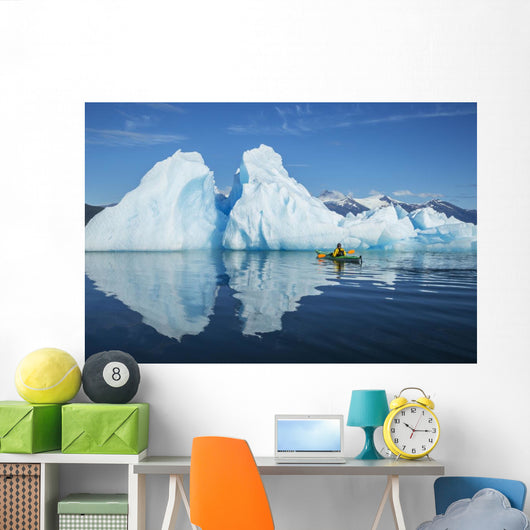 A Sea Kayaker Paddles Beside An Iceberg Wall Mural