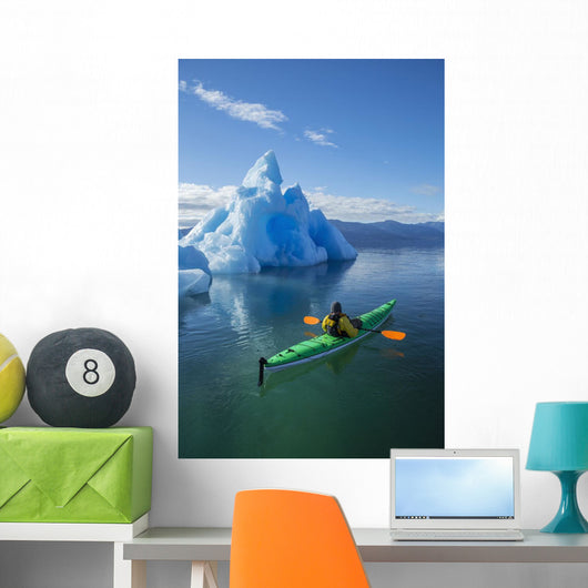 A Sea Kayaker Paddles Beside An Iceberg Wall Mural