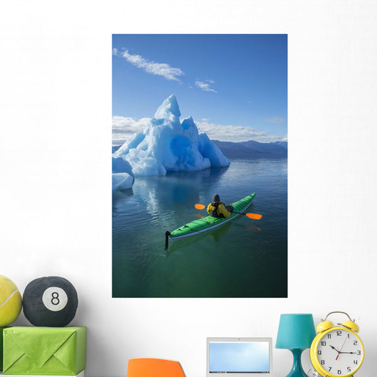 A Sea Kayaker Paddles Beside An Iceberg Wall Mural