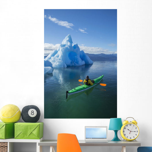 A Sea Kayaker Paddles Beside An Iceberg Wall Mural