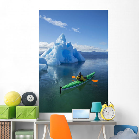 A Sea Kayaker Paddles Beside An Iceberg Wall Mural