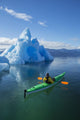 A Sea Kayaker Paddles Beside An Iceberg Wall Mural