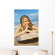 A Young Woman Lays On A Surfboard On The Sand Wall Mural