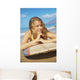A Young Woman Lays On A Surfboard On The Sand Wall Mural