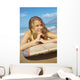 A Young Woman Lays On A Surfboard On The Sand Wall Mural