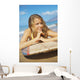 A Young Woman Lays On A Surfboard On The Sand Wall Mural
