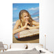 A Young Woman Lays On A Surfboard On The Sand Wall Mural