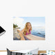 A Young Woman Wearing A Lei Rides A Surfboard Out In The Water Wall Mural