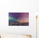 Northern lights shine above city skyline in this nighttime view Wall Mural