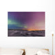 Northern lights shine above city skyline in this nighttime view Wall Mural