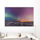 Northern lights shine above city skyline in this nighttime view Wall Mural