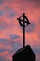 Silhouette of a cross on church steeple with fiery cloud cover Wall Mural