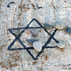 A star of david etched and painted on a rock with stones laying on it Wall Mural