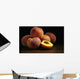 Peaches sitting on a wooden table, one cut in half Wall Mural