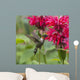 A hummingbird hovers by a bright pink blossoming flower Wall Mural