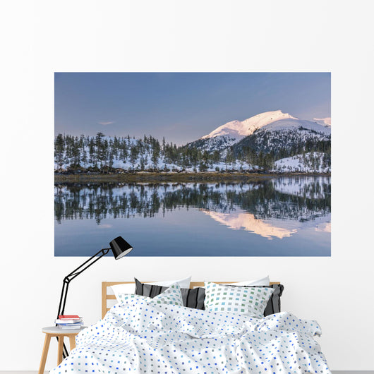 Snowy scenic reflected in the waters of Harrison Lagoon at sunrise Wall Mural