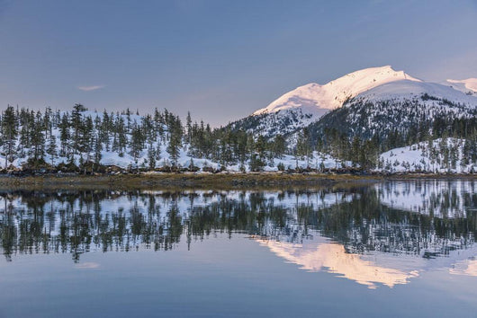 Snowy scenic reflected in the waters of Harrison Lagoon at sunrise Wall Mural
