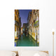 Turquoise water in a narrow canal between buildings at dusk Wall Mural