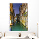 Turquoise water in a narrow canal between buildings at dusk Wall Mural