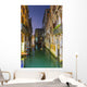 Turquoise water in a narrow canal between buildings at dusk Wall Mural