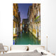 Turquoise water in a narrow canal between buildings at dusk Wall Mural
