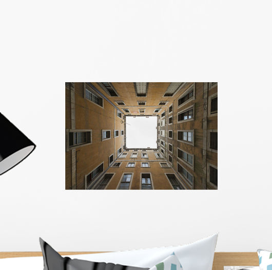 Low angle view to the sky from inside the four walls of a building Wall Mural