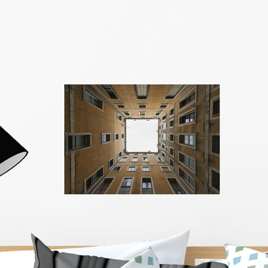 Low angle view to the sky from inside the four walls of a building Wall Mural