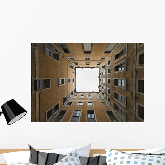 Low angle view to the sky from inside the four walls of a building Wall Mural