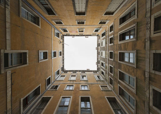 Low angle view to the sky from inside the four walls of a building Wall Mural