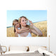 Mother drinking water in wheat field with child Wall Mural