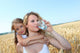 Mother drinking water in wheat field with child Wall Mural