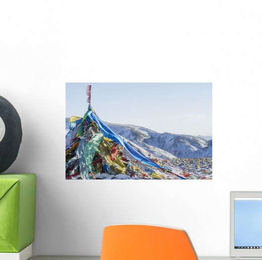 Snowy landscape with prayer flags on a high altitude mountain pass Wall Mural