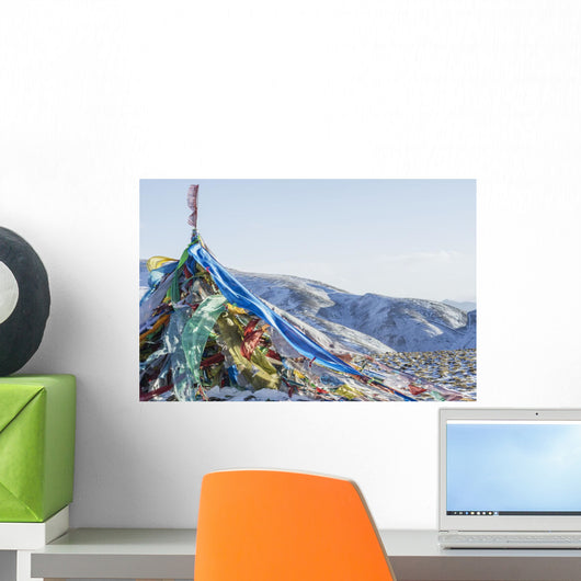 Snowy landscape with prayer flags on a high altitude mountain pass Wall Mural