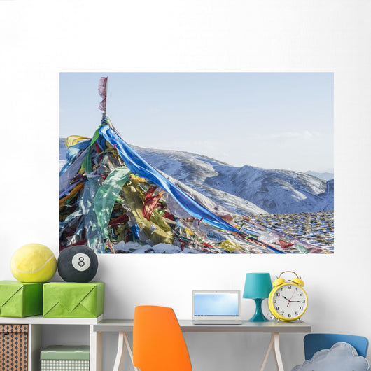 Snowy landscape with prayer flags on a high altitude mountain pass Wall Mural